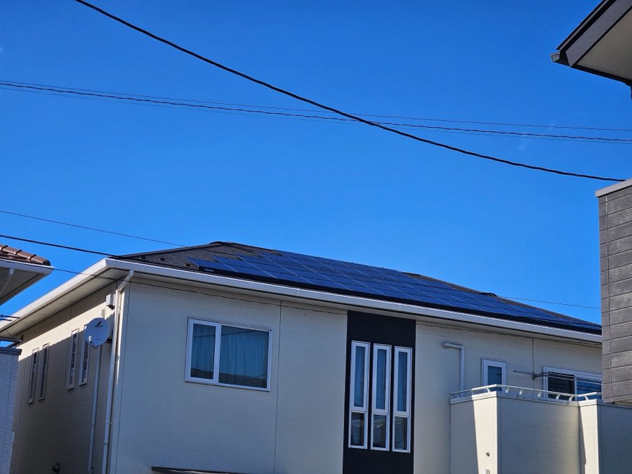 白い外壁の戸建てと寄棟屋根の太陽光パネル
